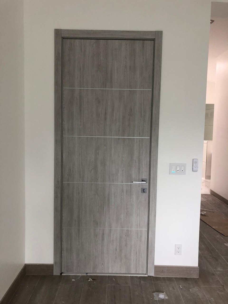 Grey wood veneer interior door with slim horizontal metal inlays