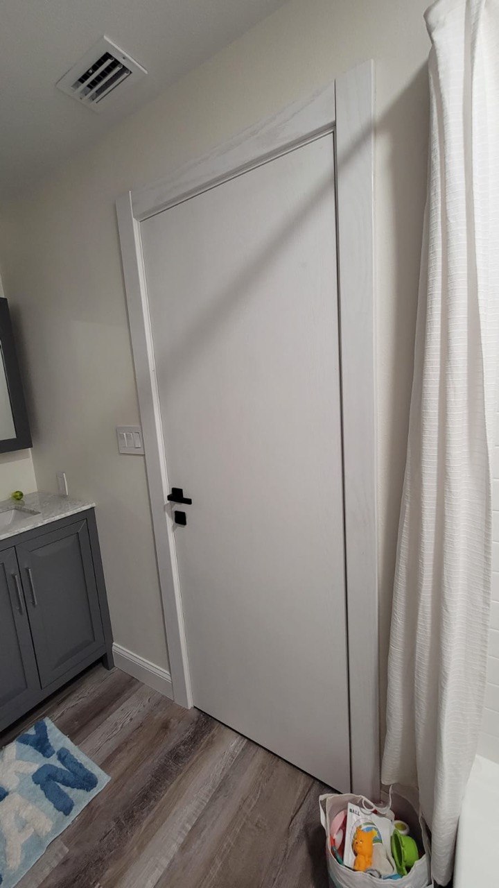 White flush interior door in a bright modern bathroom