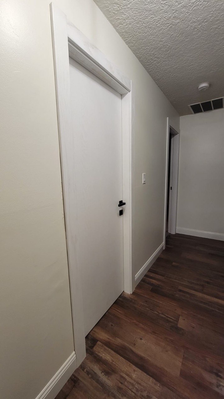 White flush interior door with slim trim in a hallway