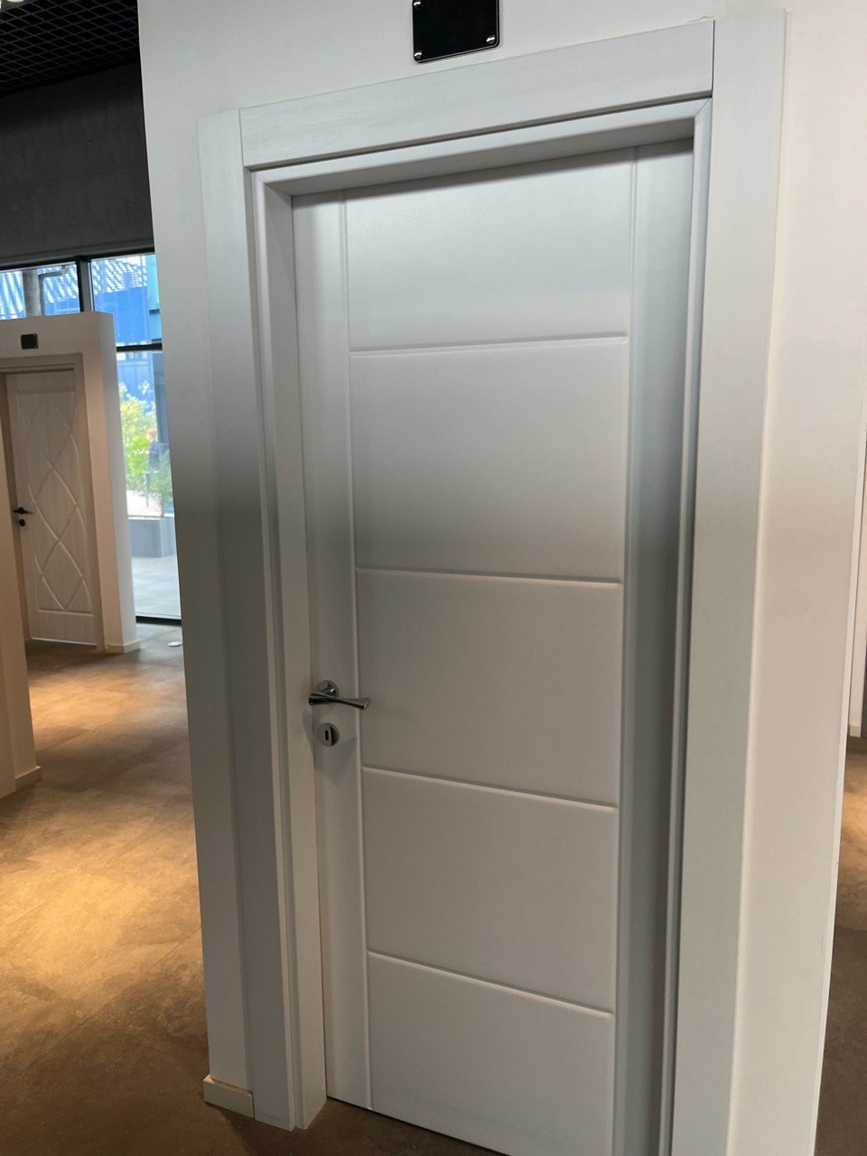 White paneled shaker interior door in a showroom