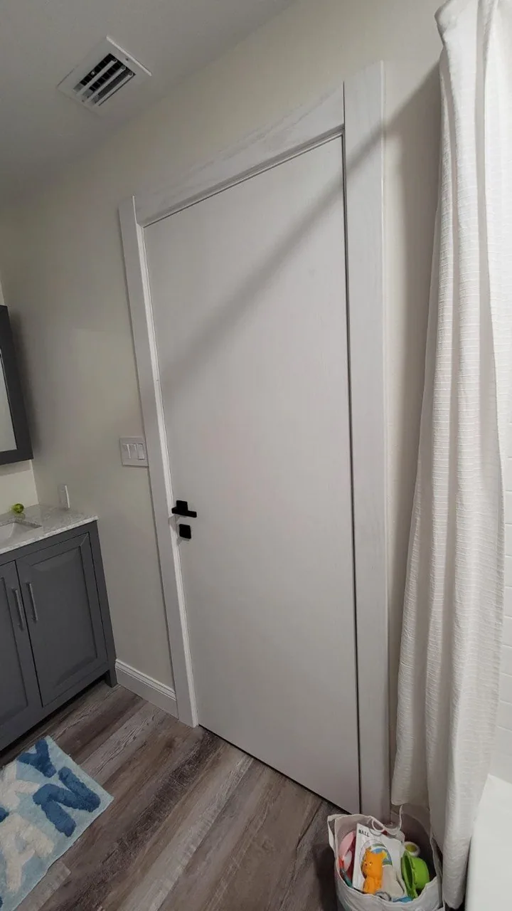 White flush interior door in a bright modern bathroom