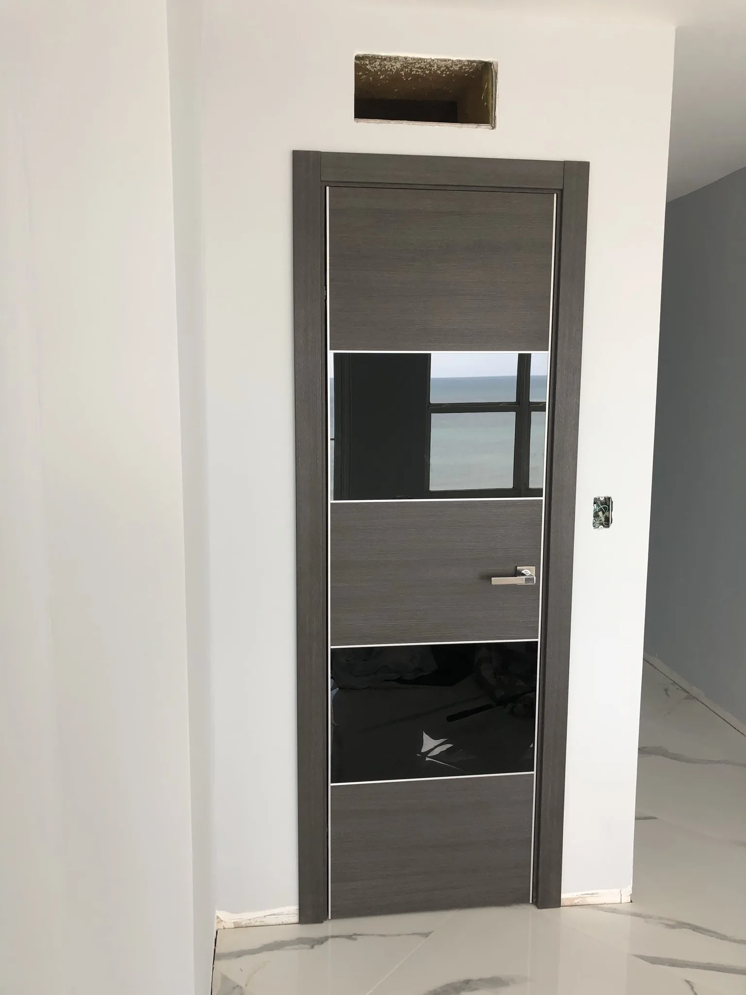 Grey woodgrain door with black-glass panels — interior door supplied and installed by Slab & Trim
