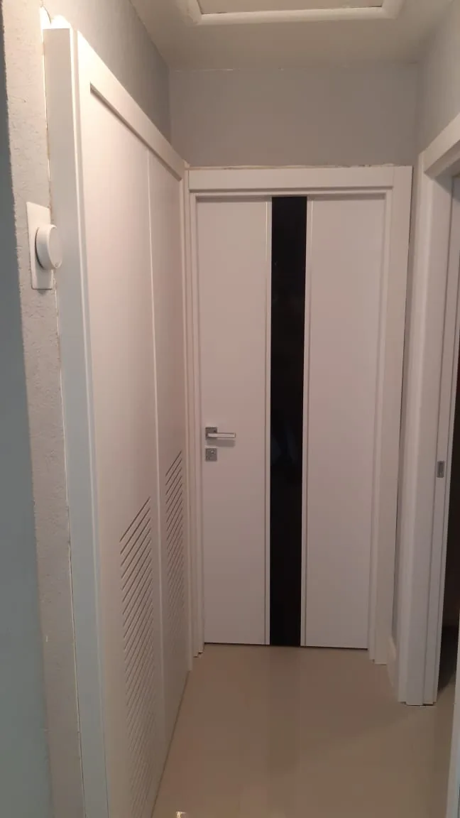 White flush door in a bright hallway — interior door supplied and installed by Slab & Trim