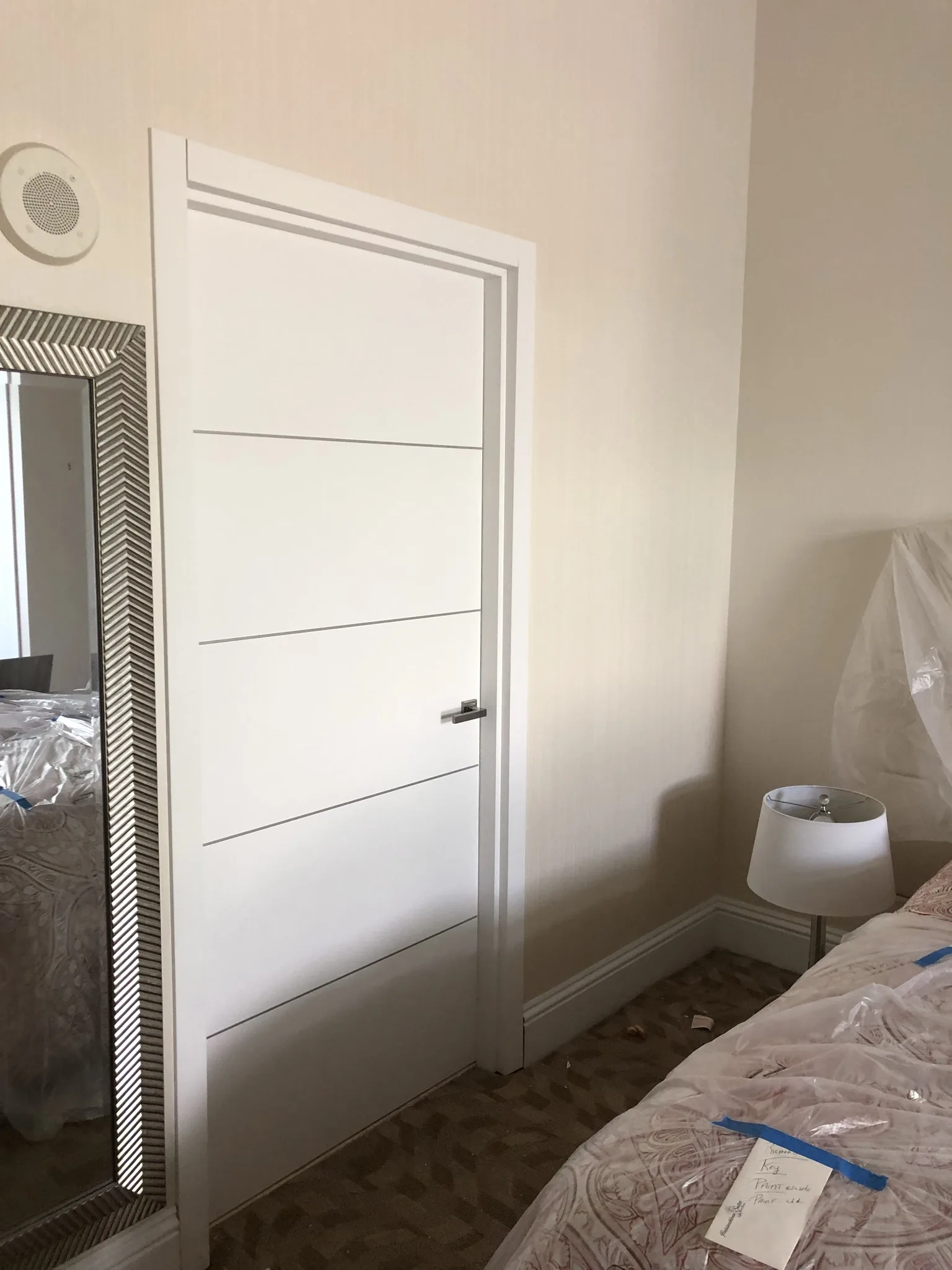 White door with aluminum inlays in a bedroom — interior door supplied and installed by Slab & Trim
