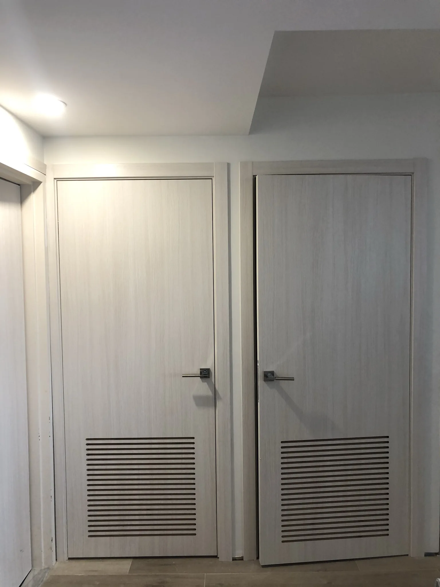 Grey woodgrain doors with louvered vents — interior door supplied and installed by Slab & Trim