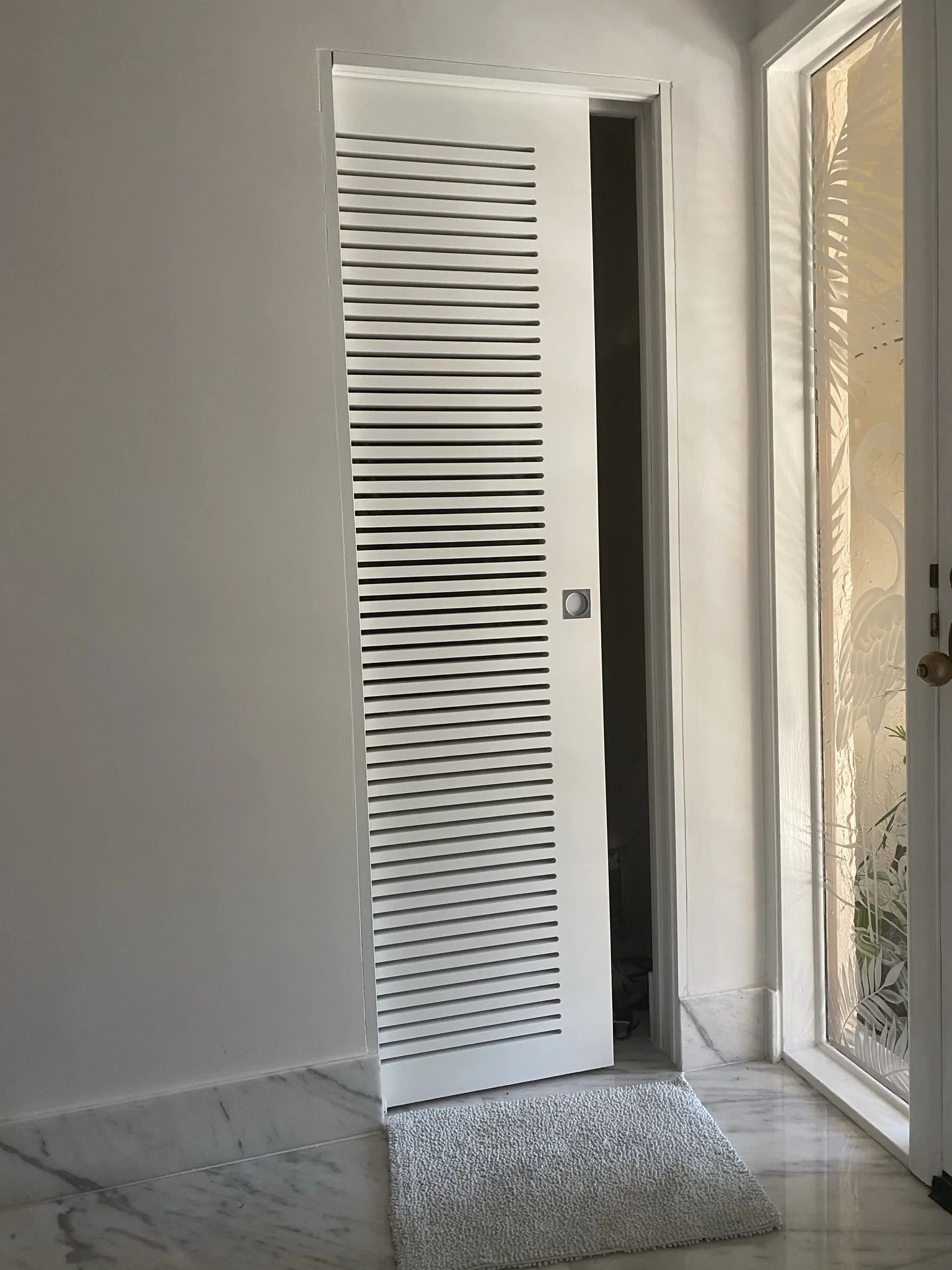 Tall white louvered closet door — interior door supplied and installed by Slab & Trim
