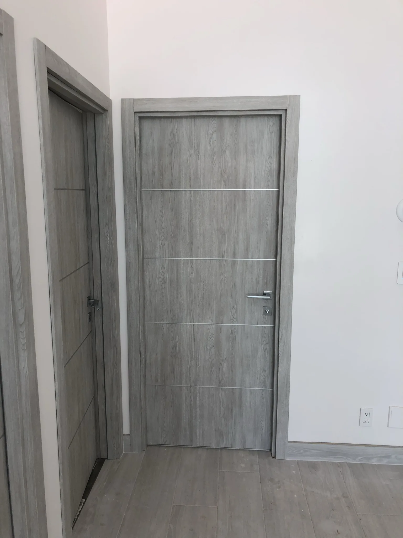 Grey woodgrain door with aluminum inlays — interior door supplied and installed by Slab & Trim