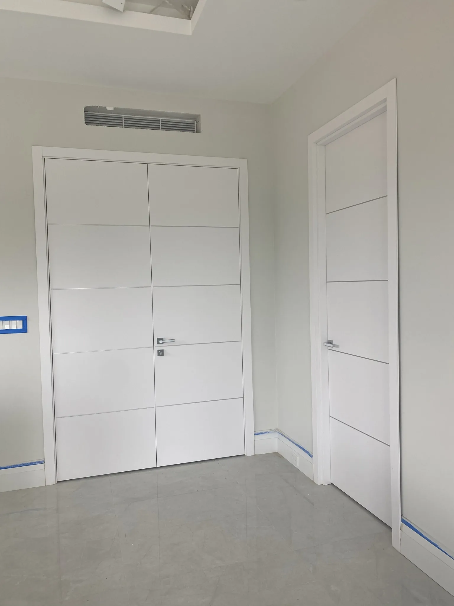 White doors with slim aluminum inlays — interior door supplied and installed by Slab & Trim