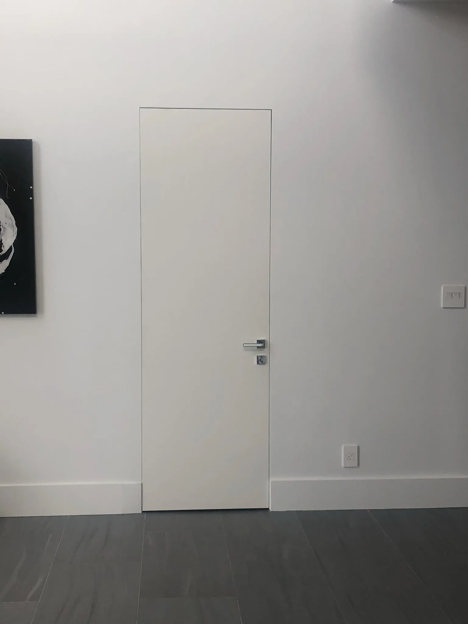 Frameless white flush door blending into the wall — interior door supplied and installed by Slab & Trim