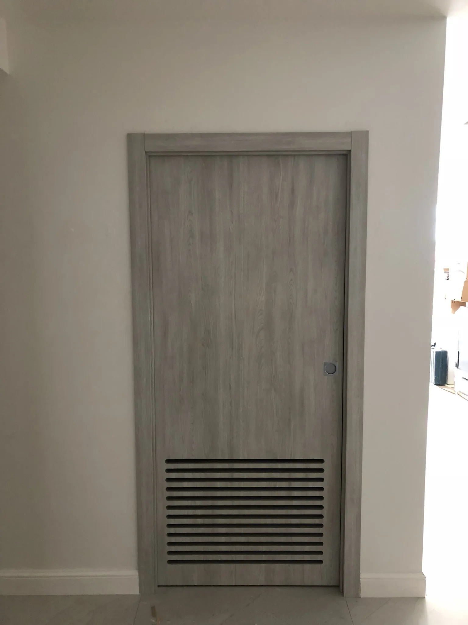 Grey woodgrain door with a louvered vent — interior door supplied and installed by Slab & Trim