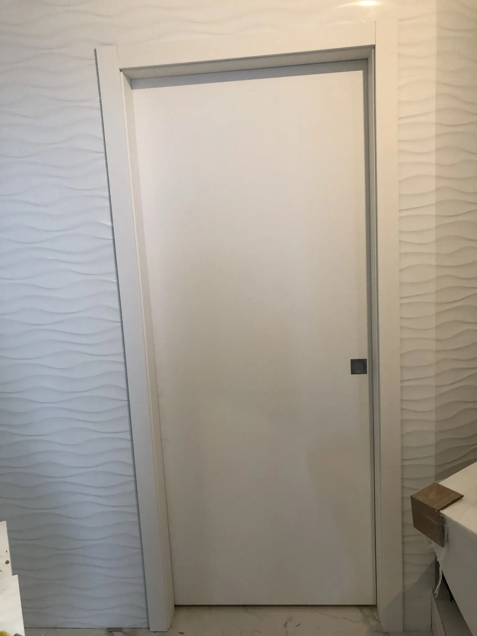 White door against a textured feature wall — interior door supplied and installed by Slab & Trim
