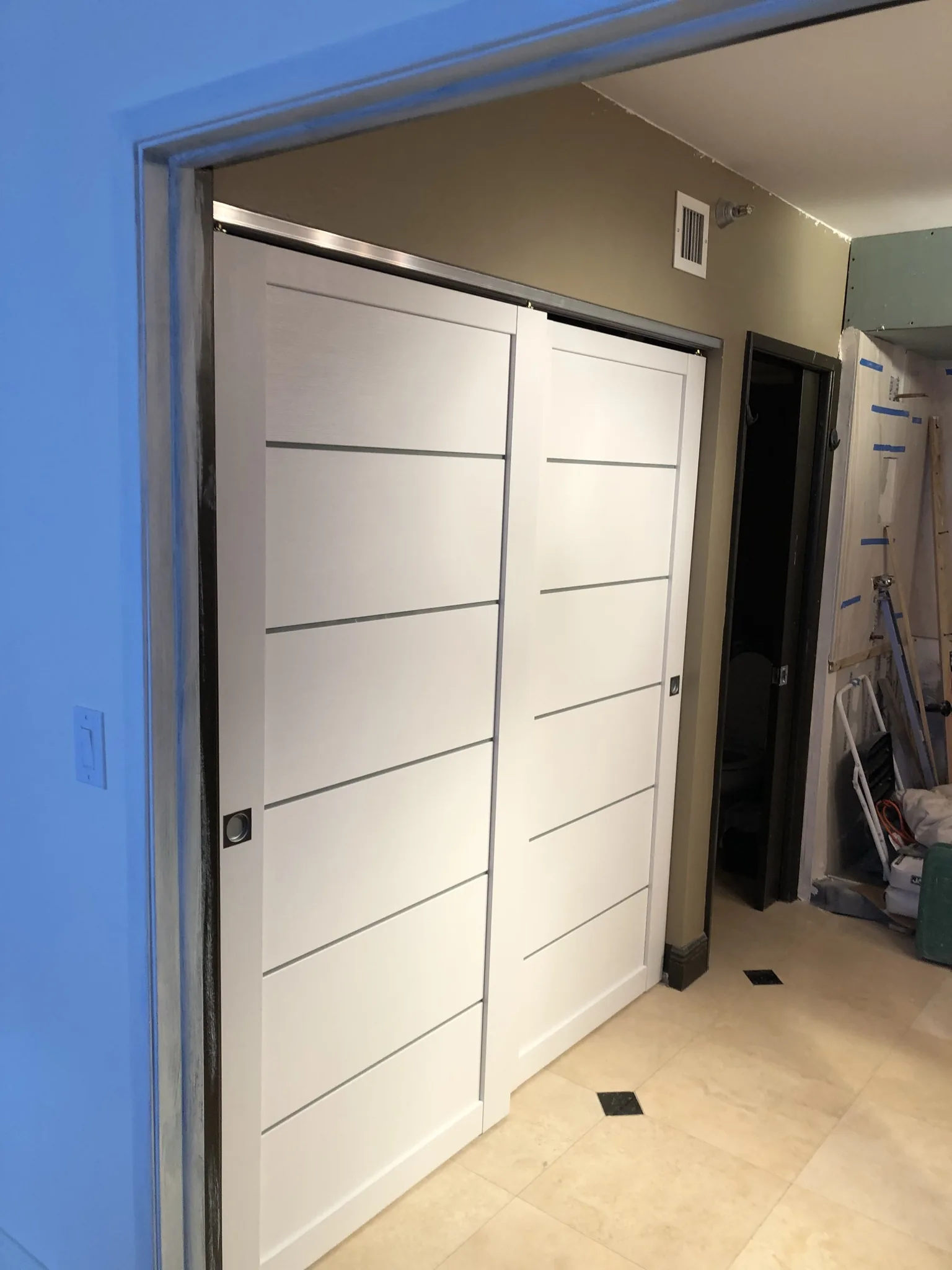 White sliding closet doors with aluminum inlays — interior door supplied and installed by Slab & Trim